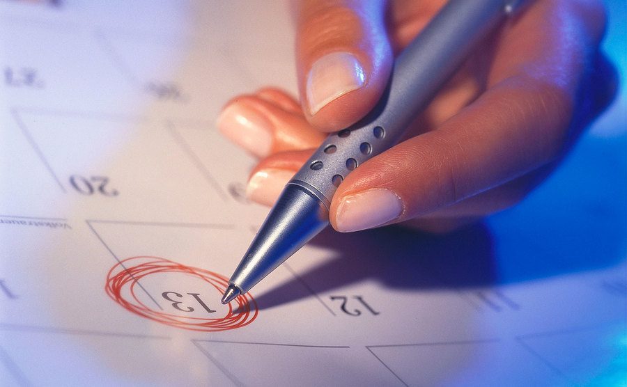 A red pen is circling a date on a calendar